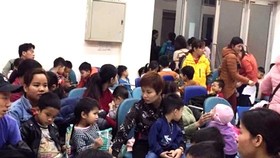 Influx of children and parents seen in hospitals in Hanoi wait for testing (Photo: SGGP)