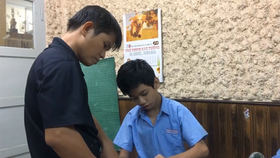 Phan Minh Thong is patiently teaching his students in the Binh Thanh School of Hope for Hearing-impaired People