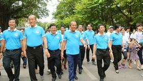 Deputy Prime Minister Truong Hoa Binh (front, fourth, left) and other people join a walk in Hanoi on June 23 (Photo: VNA)