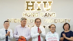 HIU President Ho Thanh Phong grants scholarship to the poor girl (Photo;l SGGP)