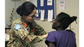 A Vietnamese doctor examines the governor's wife (Photo: SGGP)