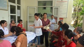 People wait for their turn for free examination (Photo: SGGP)