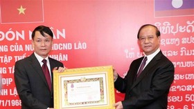 VNA General Director Nguyen Duc Loi (L) receives the second-class Isala (Freedom) Order bestowed by the Lao State. (Photo: VNA)