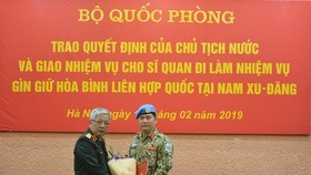 Deputy Minister of National Defence Sen. Lieut. Gen. Nguyen Chi Vinh (left) hands over the President’s decision to Lieut. Colonel Nguyen Kim Tinh. (Source: qdnd.vn)