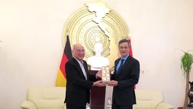 Head of the Propaganda Department of the City Party Committee Phan Nguyen Nhu Khue offers a souvenir to Vietnamese Ambassador to Germany Nguyen Minh Vu