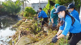 Thanh niên TPHCM tham gia dọn vệ sinh trên rạch Cây Me, quận 7 trong Ngày Chủ nhật xanh. Ảnh: VIỆT DŨNG
