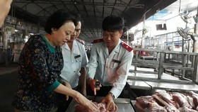 Lực lượng chức năng đang tiến hành kiểm tra thực phẩm tại chợ đầu mối Hóc Môn