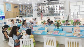 Phụ huynh và học sinh đọc sách tại ngày hội. Ảnh: PHẠM HUY