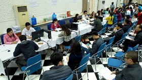 People wait for their turn to complete tax procedures at the Hanoi Tax Department.(Photo: VNA/VNS)
