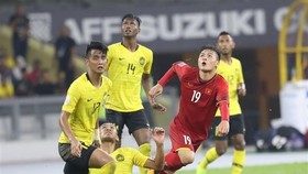 Nguyen Quang Hai (shirt no.19) is surrounded by Malaysian players (Source: VNA)