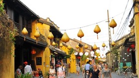 Visitors on a street in Hoi An ancient town (Photo: VNA)