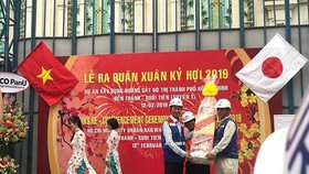 Deputy chairman of HCMC People's Committee Tran Vinh Tuyen (L) gives workers of Ben Thanh-Suoi Tien metro project New Year presents (Photo: SGGP)