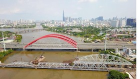 New Binh Loi Bridge is under construction in HCMC with the height from the water surface to the bridge much higher than the old adjacent one (Photo: SGGP)