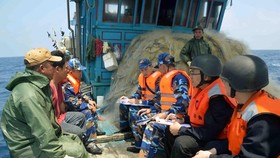 Vietnamese, Chinese coast guards inspect a Vietnamese fishing vessel in the Gulf of Tonkin (Photo: VNA)
