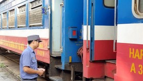A station staff waiting outside the train to Dong Dang at Gia Lam station. Photo: SGGP