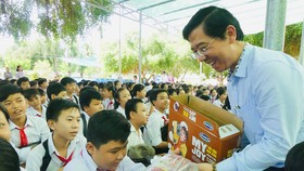 Journalist Nguyen Nhat, Deputy Editor-in-chief of SGGP Newspaper, gives students presents (Photo: SGGP)