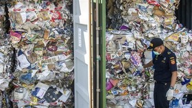 An Indonesian customs official inspects containers of waste sent from Australia (Photo: AFP/VNA)