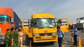 Lực lượng tiến hành kiểm tra hàng chục tài xế ra vào cảng Cát Lái, quận 2. Ảnh: CHÍ THẠCH