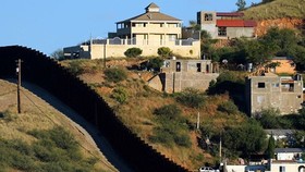Tường rào biên giới giữa 2 TP Nogales: Nogales ở bang Sonora của Mexico (phải) và Nogales ở bang Arizona của Mỹ. Ảnh: REUTERS