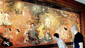 Khách tham quan xem tác phẩm sơn mài Vườn xuân Trung - Nam - Bắc của danh họa Nguyễn Gia Trí. Ảnh: AN DUNG