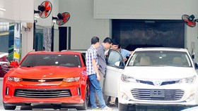 Xem ô tô nhập khẩu tại một salon ở TPHCM. Ảnh: CAO THĂNG