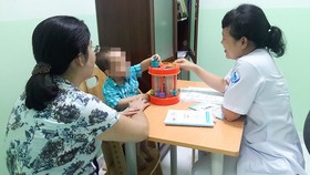Bác sĩ đang khám một trường hợp trẻ mắc chứng rối loạn tăng động giảm chú ý và và tư vấn cho phụ huynh