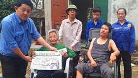 Ông Võ Tá Hiếu, Chủ tịch UBND xã Thạch Mỹ, huyện Lộc Hà, tỉnh Hà Tĩnh trao 19 triệu đồng của bạn đọc Báo SGGP cho gia đình anh Phan Huy Tình