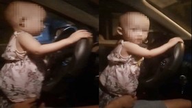 Cháu bé với hai tay đang cầm vô lăng xe ô tô. Ảnh cắt từ clip