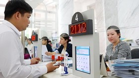 Giấy tờ đang được số hóa khi nộp làm thủ tục tại UBND quận 1. Ảnh: HOÀNG HÙNG