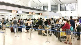 Hành khách chờ cân hành lý tại sân bay Tân Sơn Nhất. Ảnh: THÀNH TRÍ