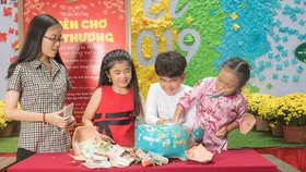 Các em thiếu nhi đập heo đất hỗ trợ các bạn đồng trang lứa có hoàn cảnh khó khăn