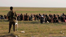 Một thành viên của Lực lượng Dân chủ Syria (SDF) giám sát những người dân ở làng Baghouz, tỉnh Deir Al Zor, Syria, ngày 22/2/2019. (Nguồn: Reuters)