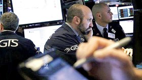 Nhân viên giao dịch theo dõi chỉ số chứng khoán tại sàn giao dịch chứng khoán New York (Mỹ)