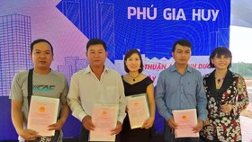 Lãnh đạo công ty trao sổ đỏ cho khách hàng
