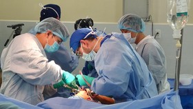 Các sác sĩ đoàn phẫu thuật từ thiện Operation Walk Chicago và BV Quân y 175 tiến hành phẫu thuật thay khớp cho bệnh nhân. Ảnh: BV cung cấp