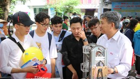 Các em học sinh thích thú với mô hình rô bốt của khoa Điện tử - Tự động HIU trong Ngày hội tư vấn xét tuyển sáng 21-7 tại Đại học Bách Khoa