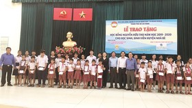 Ông Lê Văn Công, Kiểm Soát viên Công ty TNHH Một thành viên Xổ số kiến thiết TP Hồ Chí Minh cùng với lãnh đạo UBMTTQ TP, UBMTTQ huyện Nhà Bè và đơn vị Tài trợ chụp hình lưu niệm cùng với các em học sinh, sinh viên nhận học bổng