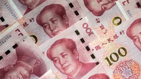 Đồng tiền mệnh giá 100 nhân dân tệ tại Bắc Kinh, Trung Quốc. (Nguồn: AFP/TTXVN)