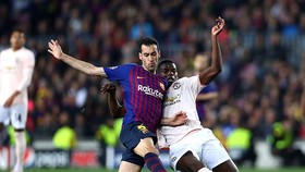 Sergio Busquets tranh bóng với Paul Pogba (phải)