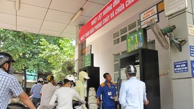 Nhân viên Petrolimex đang bán xăng cho khách hàng. (Ảnh: Đức Duy/Vietnam+)