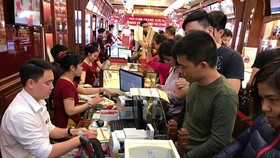 Khách hàng giao dịch vàng miếng tại Bảo Tín Minh Châu. (Ảnh: Đức Duy/Vietnam+)