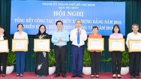 Bí thư Thành ủy TPHCM Nguyễn Thiện Nhân và Phó Trưởng Ban Tổ chức Trung ương Mai Văn Chính, chúc mừng các tập thể được nhận bằng khen. Ảnh: KIỀU PHONG