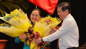 Chủ tịch UBND TPHCM Nguyễn Thành Phong tặng hoa chúc mừng đồng chí Nguyễn Thị Lệ. Ảnh: VIỆT DŨNG
