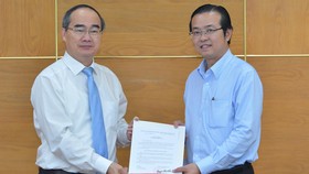 Đồng chí Nguyễn Thiện Nhân, Ủy viên Bộ Chính trị, Bí thư Thành ủy TPHCM, trao quyết định điều động, bổ nhiệm cho đồng chí Lê Văn Minh. Ảnh: VIỆT DŨNG