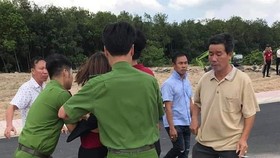Công an khống chế đưa một nhân viên của Công ty địa ốc Alibaba về trụ sở. Ảnh: P.T.