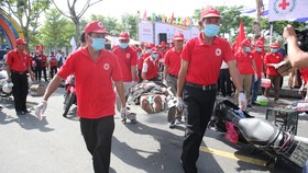 Các tình nguyện viên Chữ thập đỏ di chuyển người bị thương đến xe, điểm cấp cứu
