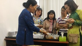 Pastry chef Truong Thi Chieu (L) introduces her cakes to visitors at the press conference of the vent. (Photo: Sggp)