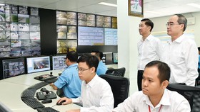 Secretary of HCMC Party Committee Nguyen Thien Nhan (Standing,R ) visits the Traffic Control and Monitoring Center in HCMC. (Photo: Sggp)