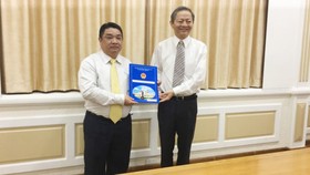 Phó Chủ tịch UBND TPHCM Lê Văn Khoa trao quyết định cho ông Võ Khánh Hưng (phía bên trái).