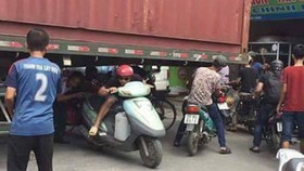 Bất chấp nguy hiểm, người dân chui gầm container để lưu thông
